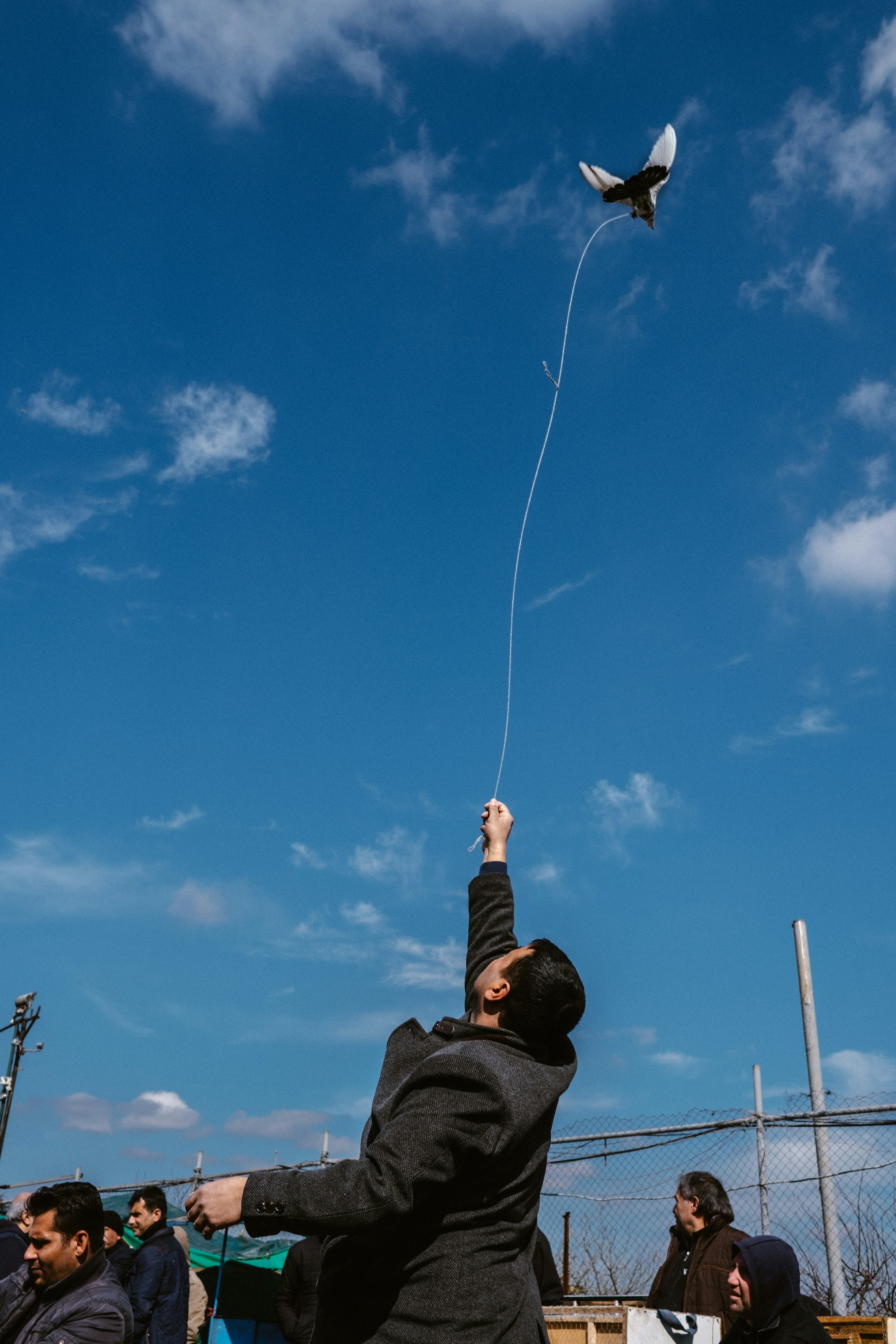 person in black jacket and brown pants under blue sky with white clouds during daytime